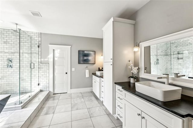 bathroom featuring a stall shower, baseboards, a sink, marble finish floor, and two vanities