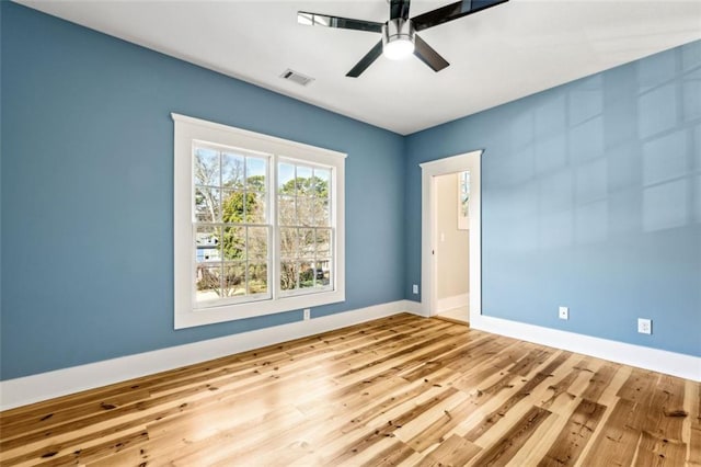 unfurnished room with a ceiling fan, baseboards, visible vents, and wood finished floors