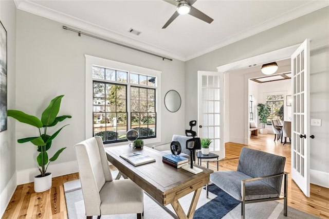 office space with french doors, crown molding, light wood finished floors, visible vents, and baseboards