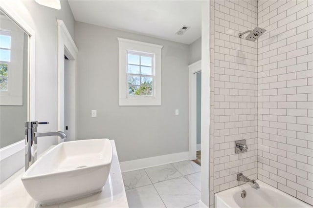 full bathroom with marble finish floor, shower / bath combination, visible vents, a sink, and baseboards