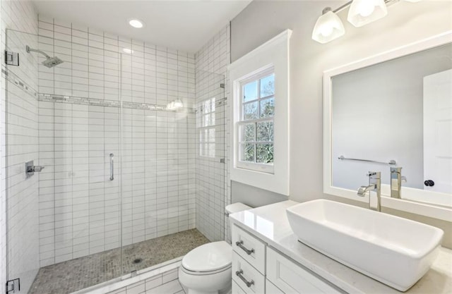 full bathroom with a stall shower, vanity, toilet, and recessed lighting