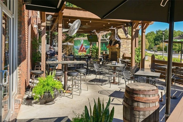 view of patio with an outdoor stone fireplace and outdoor dining area