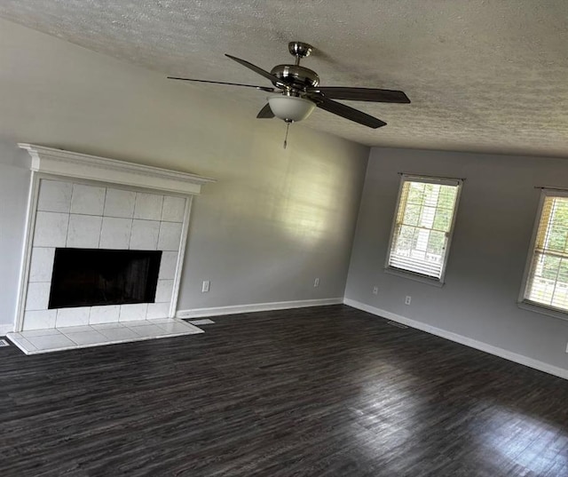 161 Honey Creek Rd, Mcdonough, GA 30252 - unfurnished living room featuring a textured ceiling, dark wood-style floors, ceiling fan, baseboards, and a tiled fireplace
