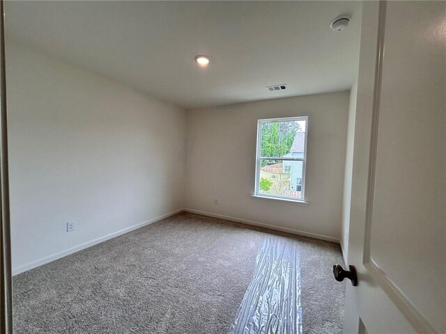 carpeted spare room with baseboards and visible vents