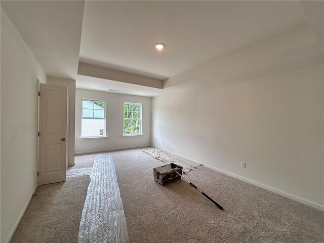 spare room featuring baseboards, carpet flooring, and a tray ceiling