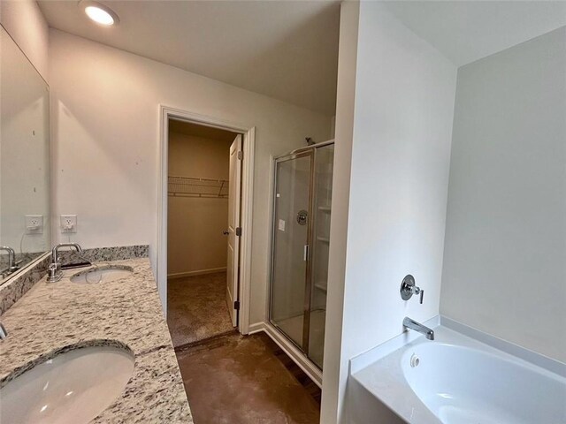 full bath featuring a garden tub, a sink, a walk in closet, and a stall shower