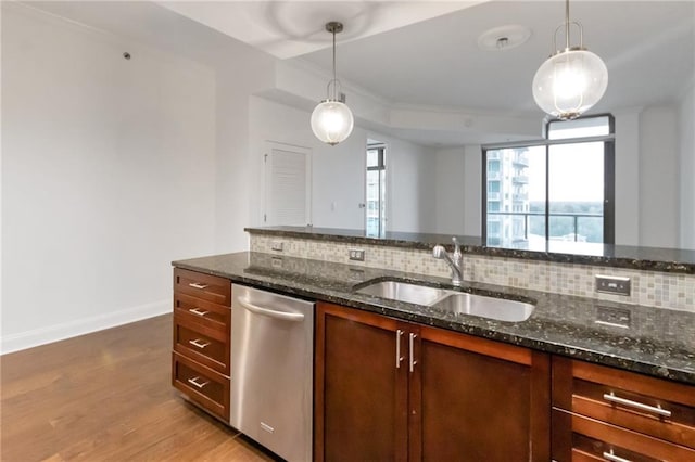 kitchen featuring decorative light fixtures, dark stone countertops, decorative backsplash, and sink