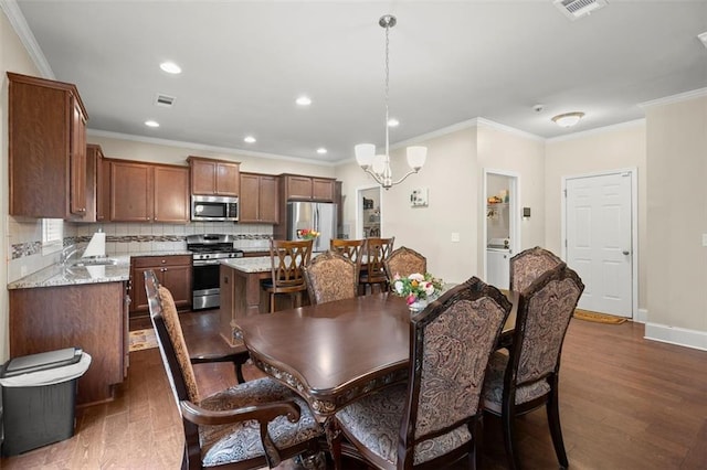 1709 Grove Ct SE, Conyers, GA 30013 - dining area featuring dark wood-style flooring, ornamental molding, recessed lighting, a chandelier, and baseboards