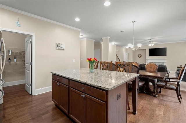 1709 Grove Ct SE, Conyers, GA 30013 - kitchen featuring ornamental molding, a breakfast bar area, dark wood-type flooring, baseboards, and a ceiling fan