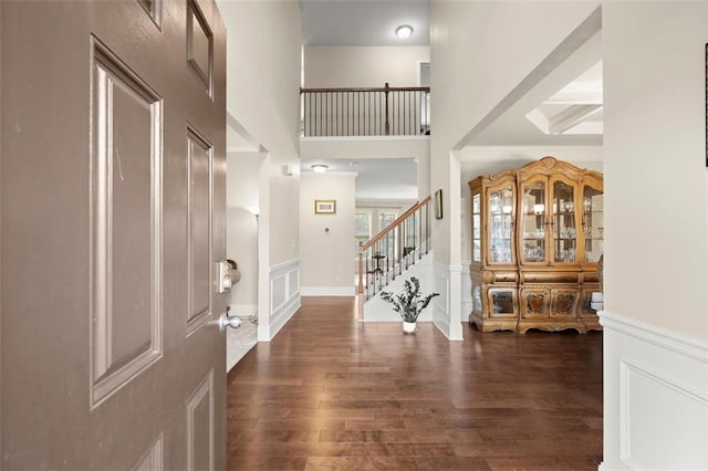 1709 Grove Ct SE, Conyers, GA 30013 - foyer featuring wood finished floors, stairs, a high ceiling, wainscoting, and a decorative wall