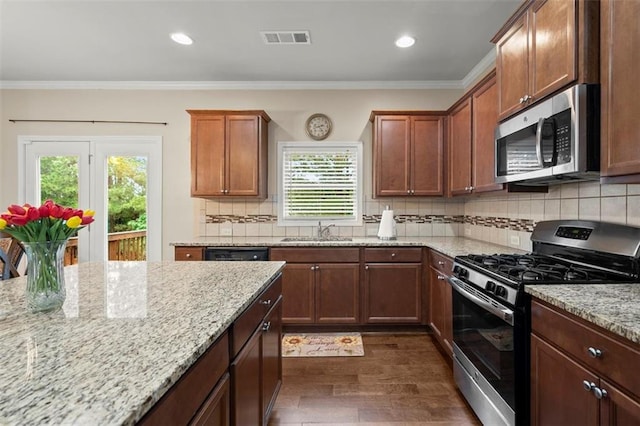 1709 Grove Ct SE, Conyers, GA 30013 - kitchen with appliances with stainless steel finishes, a sink, dark wood-style flooring, plenty of natural light, and ornamental molding