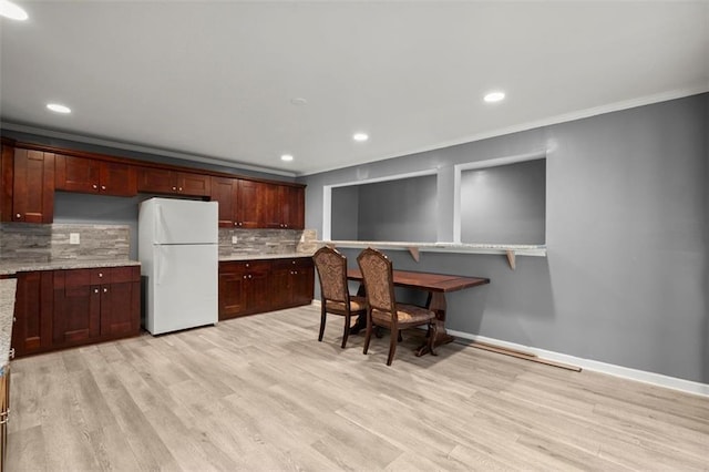 1709 Grove Ct SE, Conyers, GA 30013 - kitchen featuring freestanding refrigerator, decorative backsplash, light wood-style flooring, crown molding, and baseboards