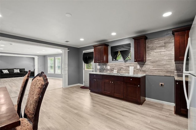 1709 Grove Ct SE, Conyers, GA 30013 - kitchen with crown molding, decorative backsplash, light wood-type flooring, recessed lighting, and baseboards