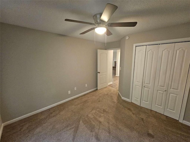 unfurnished bedroom featuring a closet, a textured ceiling, carpet flooring, and ceiling fan