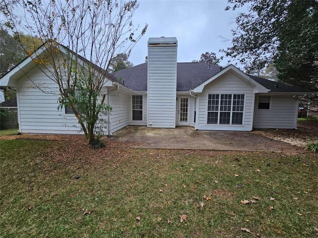 rear view of house with a lawn and a patio