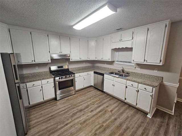 kitchen featuring stainless steel appliances, white cabinetry, sink, and hardwood / wood-style floors