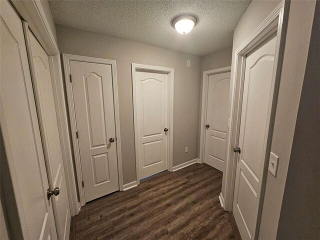 hallway featuring dark hardwood / wood-style floors and a textured ceiling