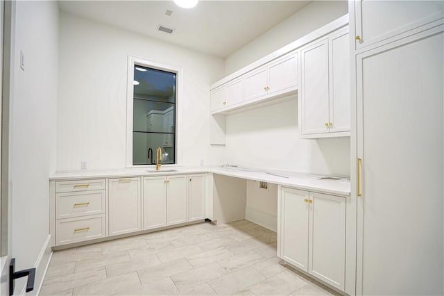 kitchen with white cabinetry and sink