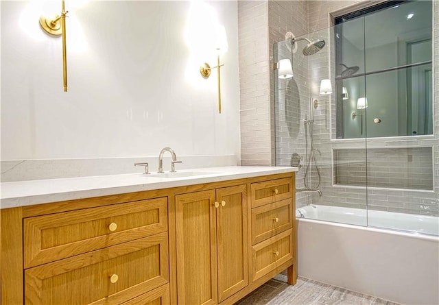 bathroom featuring combined bath / shower with glass door and vanity