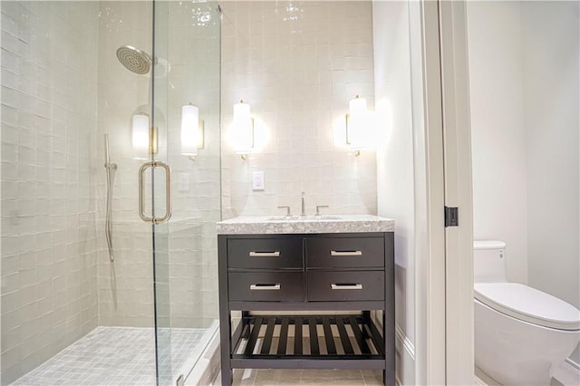 bathroom featuring tile patterned flooring, vanity, toilet, and an enclosed shower