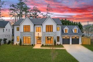 modern farmhouse featuring a garage and a lawn