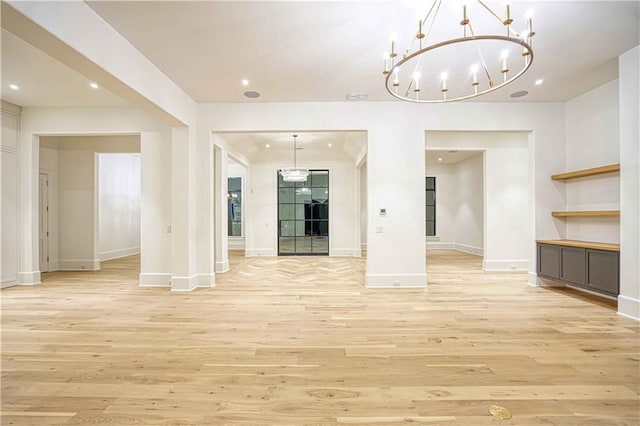 unfurnished dining area featuring light wood-type flooring and an inviting chandelier