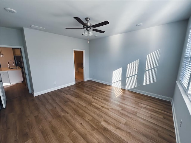 unfurnished room featuring ceiling fan, sink, and dark hardwood / wood-style floors