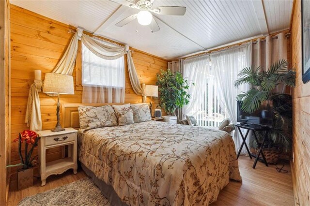 65 Bear Mountain Trl, Cleveland, GA 30528 - bedroom with wooden walls, multiple windows, a ceiling fan, and wood finished floors