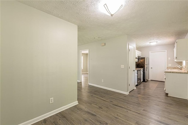 interior space with a textured ceiling, sink, and dark wood-type flooring