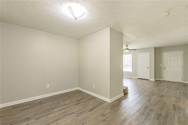 spare room featuring a textured ceiling, dark hardwood / wood-style flooring, and ceiling fan