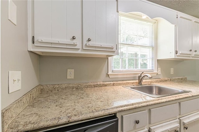 kitchen featuring white cabinets, stainless steel dishwasher, and sink