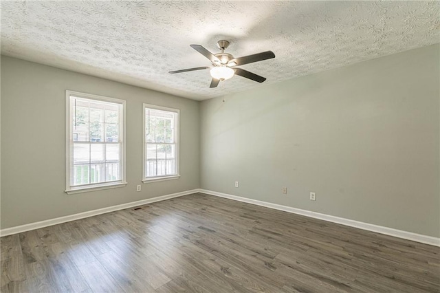 empty room with dark hardwood / wood-style floors, ceiling fan, and a textured ceiling