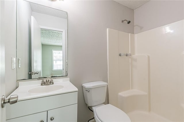 bathroom with toilet, vanity, and walk in shower