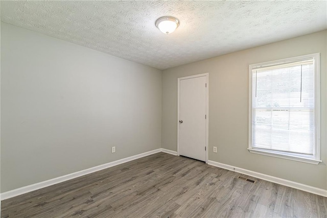 empty room featuring hardwood / wood-style floors and a textured ceiling