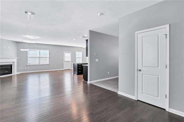 unfurnished living room with dark hardwood / wood-style floors and a premium fireplace