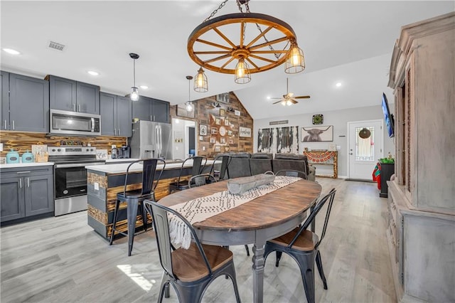 dining area featuring light hardwood / wood-style floors, ceiling fan, and vaulted ceiling