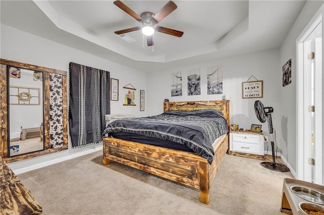 bedroom featuring a tray ceiling, ceiling fan, and carpet floors