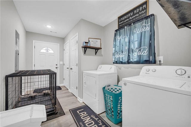 laundry room featuring a wealth of natural light, independent washer and dryer, and light hardwood / wood-style floors