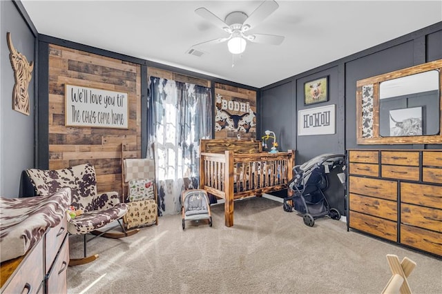 bedroom with wood walls, ceiling fan, and carpet