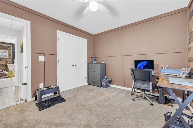 carpeted office space with ceiling fan