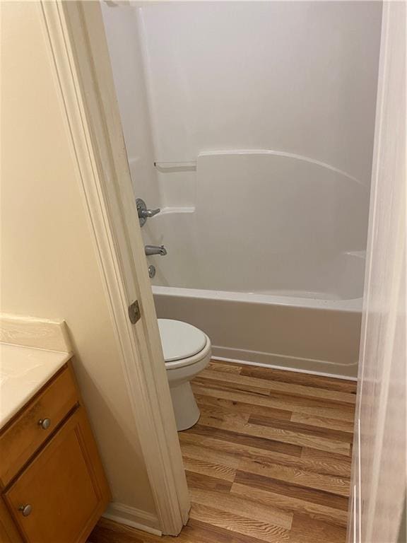 full bathroom featuring vanity, wood-type flooring, shower / tub combination, and toilet