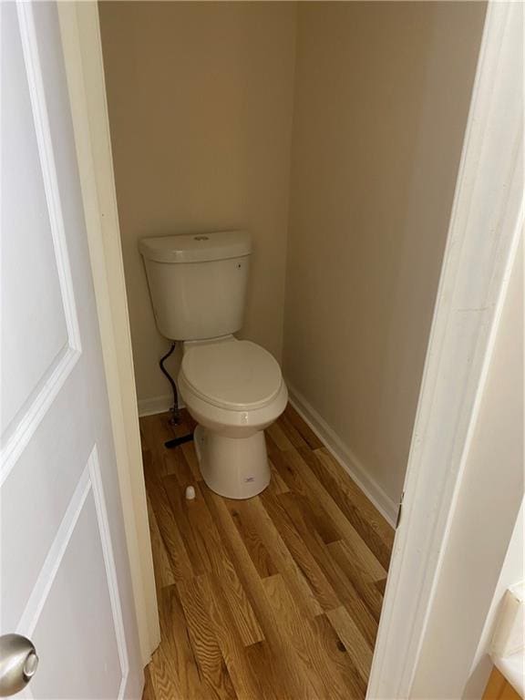 bathroom with wood-type flooring and toilet