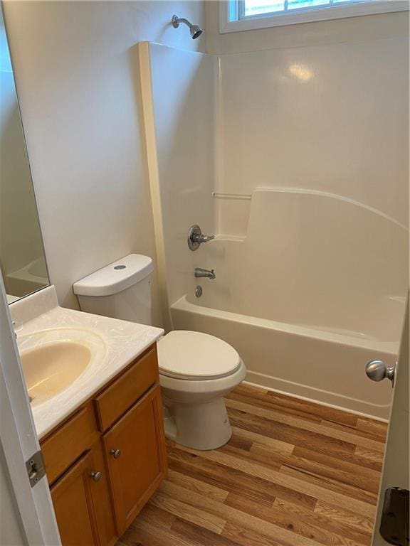 full bathroom with vanity, hardwood / wood-style flooring, shower / washtub combination, and toilet