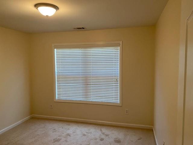 unfurnished room featuring light carpet