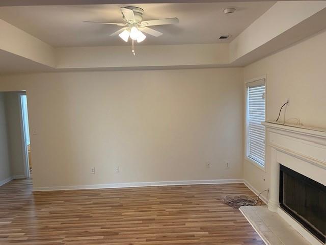 unfurnished living room with ceiling fan and wood-type flooring