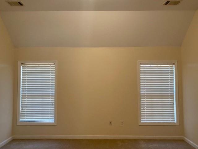 unfurnished room with vaulted ceiling and light carpet