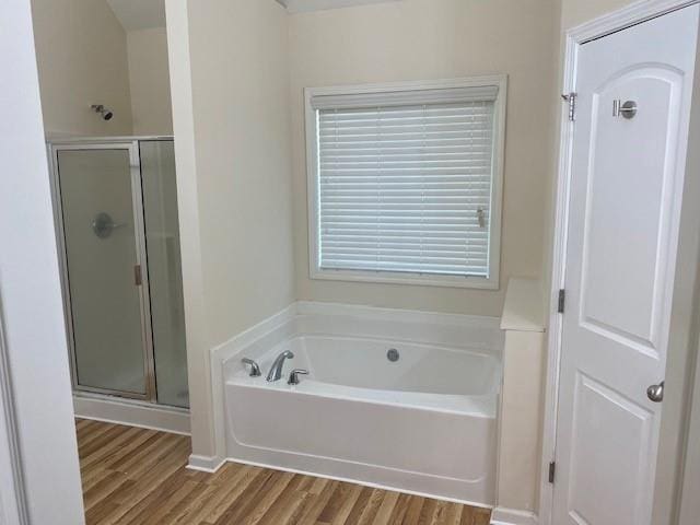 bathroom featuring wood-type flooring and shower with separate bathtub