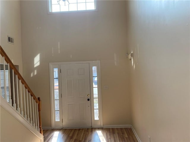 foyer entrance featuring hardwood / wood-style flooring and a high ceiling