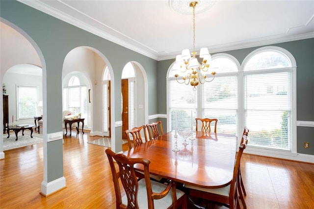 dining room featuring crown molding, light wood finished floors, and a chandelier