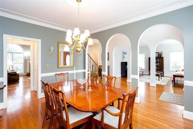 dining space featuring a wealth of natural light, a chandelier, crown molding, and light wood-type flooring